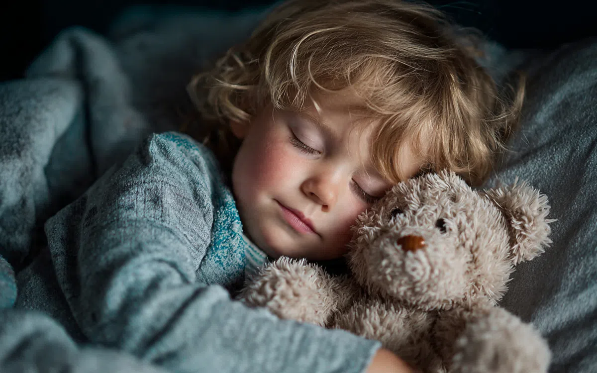 Enfant dormant avec son doudou.
