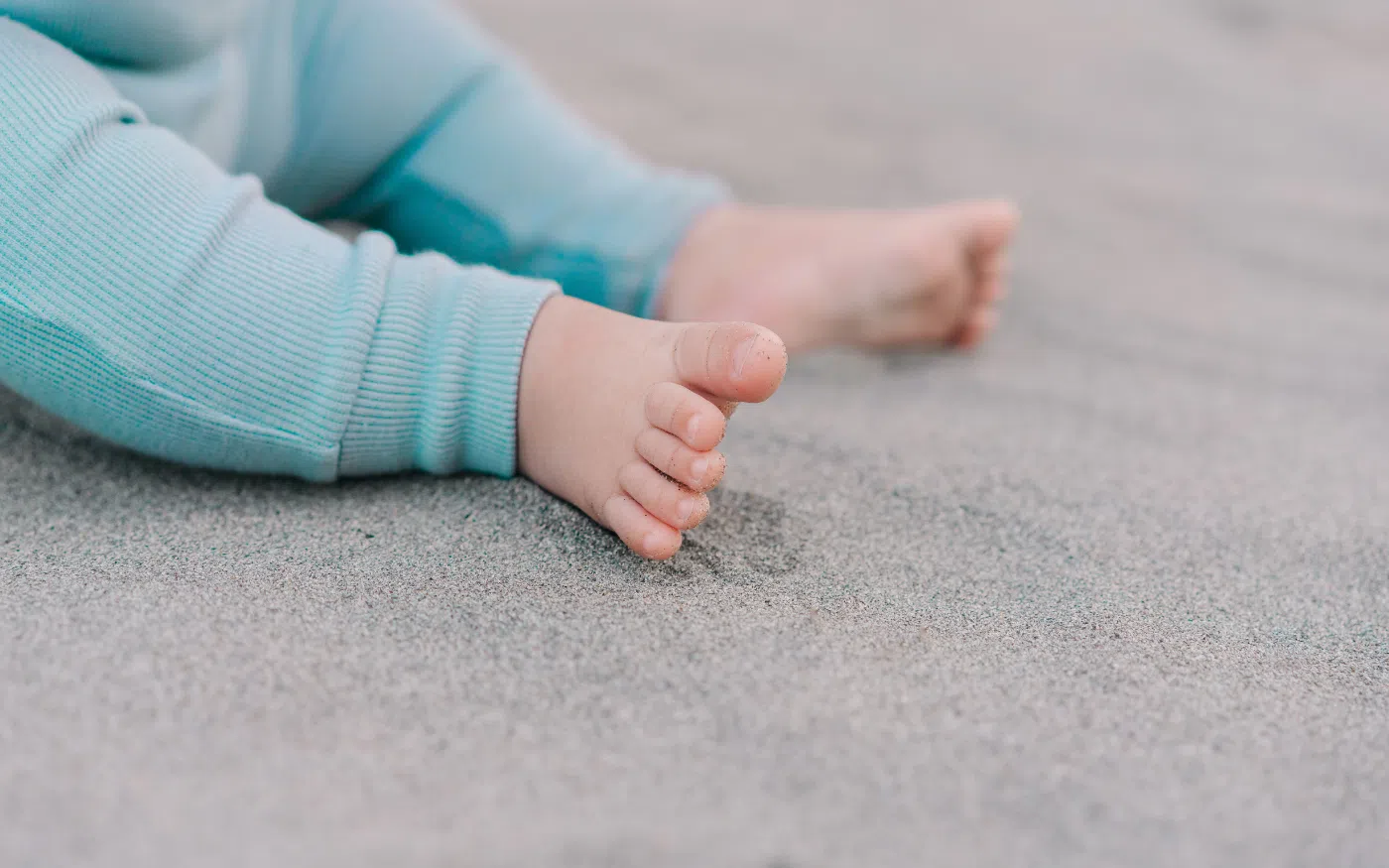 Bébé pieds nus dans le sable.