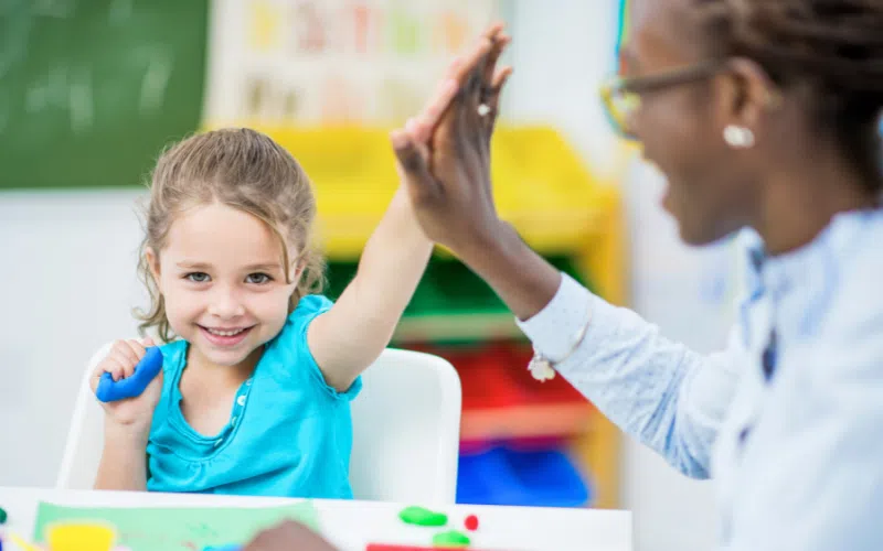 Éducatrice qui fait du renforcement positif.